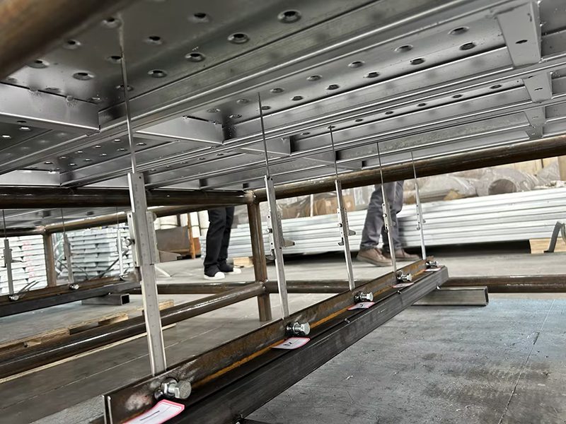 Deformasi dan perpindahan papan perancah tertutup sepanjang 4 meter di bawah beban 5,6 ton.